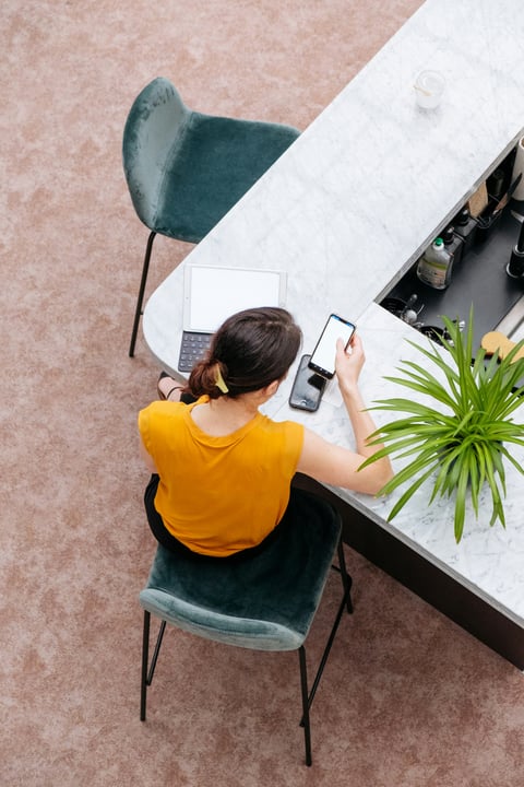 Person arbeitet an einem Schreibtisch mit Laptop und Notizen